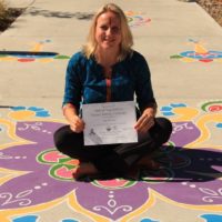 Yoga teacher sitting showing her training graduation certificate | Santosh Yoga Institute in Salt Lake City, UT