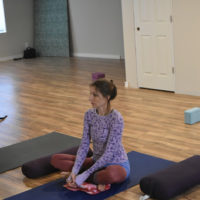 Young woman sitting on yoga mat | Santosh Yoga Institute in Salt Lake City, UT
