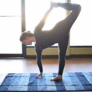 Woman doing yoga using cotton-yoga-rug mat in Salt Lake City, UT | Santosh Yoga Institute