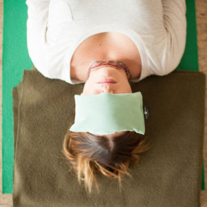 Woman using Peachskin Yoga Eye Pillow in Salt Lake City, UT | Santosh Yoga Institute