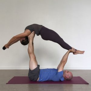 Flexible woman & man doing yoga exercise using Tapas Ultra Yoga Mat in Salt Lake City, UT | Santosh Yoga Institute