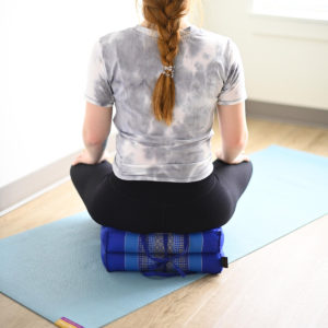 Young girl sitting on Zafuko Foldable Yoga & Meditation Cushion in Salt Lake City, UT | Santosh Yoga Institute