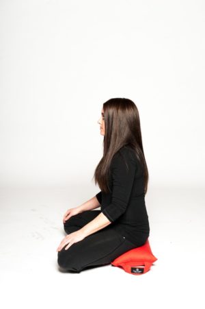 Woman doing meditation while sitting on Sukasana Cushion in Salt Lake City, UT | Santosh Yoga Institute