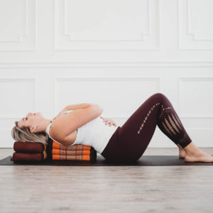 Young woman doing yoga using Zafuko Yoga & Meditation Cushion in Salt Lake City, UT | Santosh Yoga Institute